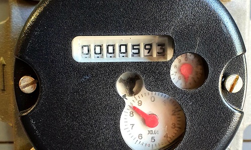A black metered standpipe with two red dials, the larger of which points to the number you must note for your meter reading.