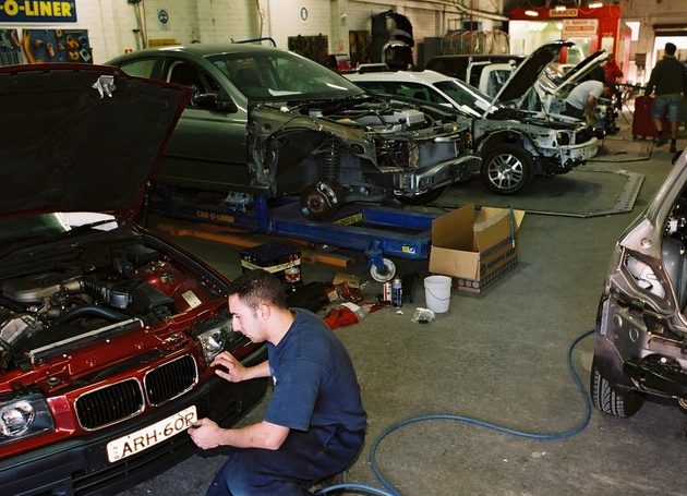 Mechanic in automotive workshop working on car