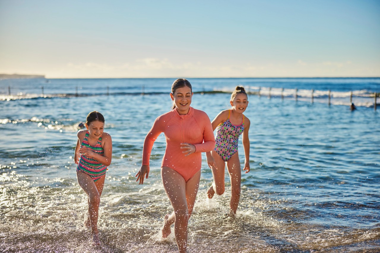 Children running along beach